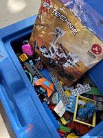 Carry case interior showing assorted loose LEGO pieces and sealed Technic Mars rover polybag