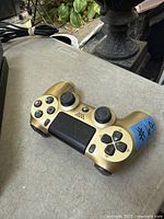 Gold PlayStation 4 DualShock 4 wireless controller on table