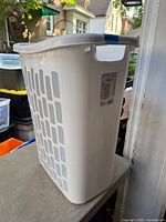 Side view of white Sterilite laundry hamper showing vent holes and top rim