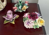Three porcelain floral pieces on tabletop