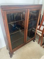 Front view showing glass doors, shelves, feet