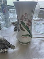 Porcelain floral vase with surrounding glass pieces visible