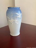 Front view of porcelain vase showing seagull motif, blue gradient, gold rim