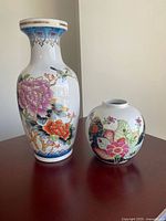 Front view of both porcelain vases showing decoration and relative sizes