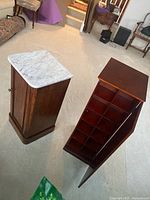 Media tower and marble-top cabinet side by side, doors open showing interior