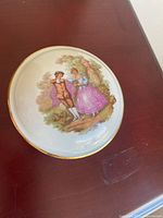 Top view of Limoges candy dish lid showing courting scene and gold rim