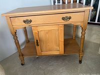 Front view showing drawer, cabinet door, lower shelf and casters