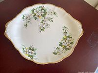 Front view of plate showing floral Dogwood motif, scalloped gold rim