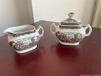 Front view of creamer and sugar bowl with lid showing pattern and shape