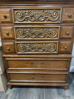 Front view showing entire dresser with seven drawers and carved details