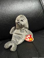 Front view of grey Ty Beanie Babies seal with swing tag