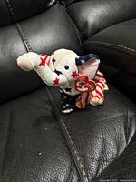 Front view showing full elephant plush on black leather surface