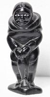Front view of dark soapstone carving depicting hunter holding fish