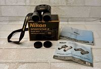 Binoculars with box, strap, lens caps, manuals