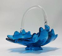 side view showing blue glass body, clear handle, ruffled rim