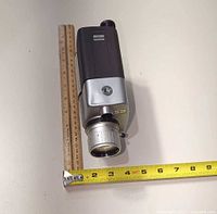 Front and side view of Argus Model 812 camera next to rulers for scale