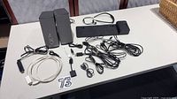 Full lot view with Bose speakers, HP dock, Roku stick, earbuds and cables