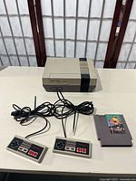 NES console, two controllers, Pac-Man cartridge displayed on table