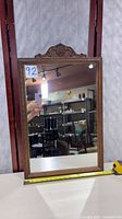 Front view of the ornate wood framed mirror showing full frame and glass