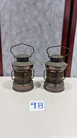 Front view of both matching metal oil lanterns