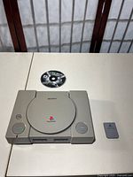 Top view of Sony PlayStation console, game disc, memory card