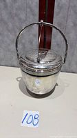 Front view of Thermos silverplate insulated ice bucket showing swing handle and lid