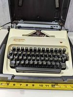Typewriter inside open carrying case showing keyboard and overall condition