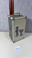 Full view of closed cream/gray doll trunk showing poodle graphic and latch