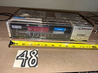 Front view showing LED display, tuner scale, branding