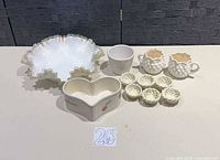 Group shot of all items: milk glass dish, two hobnail creamers, six rosette candle holders, heart planter, cylinder planter