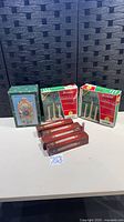 Boxed musical Christmas clock, two boxed 3-light window candoliers, three boxed single-light candle lamps visible