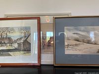 All three framed paintings standing on surface