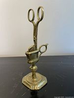 Brass candle snuffer mounted on stand, full view
