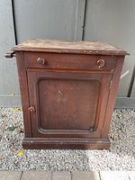 Front view of antique wash stand showing drawer, cupboard door and overall form