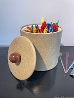 Ice bucket with lid removed showing swizzle sticks inside