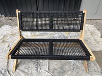 Front view of wood-framed bench showing black woven mesh seat and back