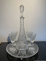 Full view of crystal decanter with stopper, four glasses and tray