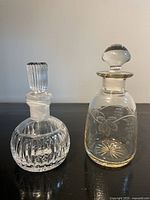 Front view of both perfume bottles with stoppers in place