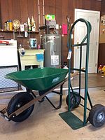 Wheelbarrow and hand truck standing in garage, side view of both items