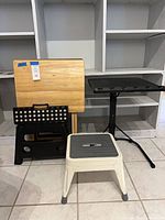 All four items grouped: wood TV tray, black tripod stand, black folding step stool, white Cosco step stool