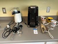 Full lot on countertop showing all appliances, attachments and mugs