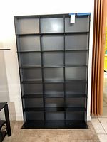 Full front view of black cubby bookshelf showing all compartments
