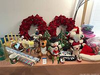 Overall view showing wreaths, plush, trees, lights, wrap, mugs and accessories
