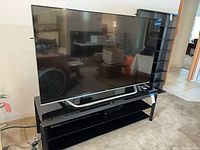 Front view of LG 65UF8500 television on stand with DVD player below