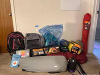 Full lot overview showing backpacks, chair, tent, sleeping bags, gear bags and accessories