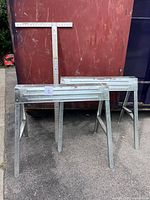 Overall view of two sawhorses and T-square standing upright