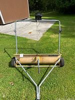 Front view showing full sweeper, hitch, wheels, and mounted battery charger sitting on frame