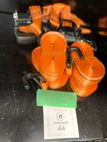 Stack of four orange ratcheting straps with S-hooks