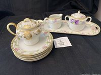 Full lot showing tray, stacked plates, violet sugar and creamer, gold creamer