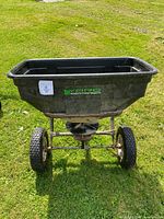 Front view of Yard Commander seeder showing hopper, wheels, hitch